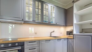 Una cocina moderna con gabinetes grises, encimera de madera y horno empotrado.