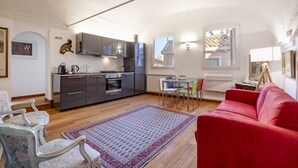 A compact living space with a kitchenette, a dining area, and a red sofa.