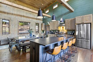 A spacious kitchen with a large island, bar stools, and modern appliances. - 5 min to Downtown Blue Ridge with Sunrise Views -Sauna -Hot Tub -Firepit (Blue Ridge)