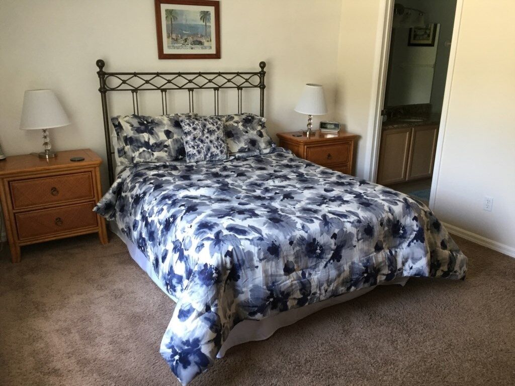 A bedroom with a bed, two bedside tables, and a nightstand.