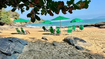 Na praia, guarda-sóis, bar na praia