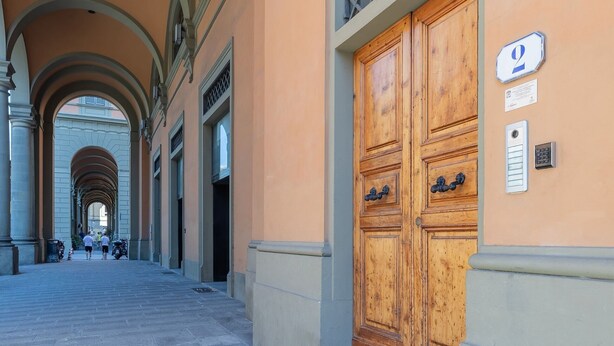 Un pasillo con una gran puerta de madera, techo abovedado y un cartel que indica el número 2.