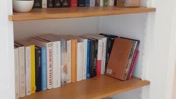 Een boekenplank met verschillende boeken, een klein schaaltje en een decoratief object.