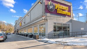 A Planet Fitness building with large windows and a parking lot.