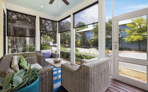 A sunroom with wicker furniture, large windows, and a view of the outside. - Here Comes the Sun Watercolor, Bikes & Pool Access (Santa Rosa Beach)