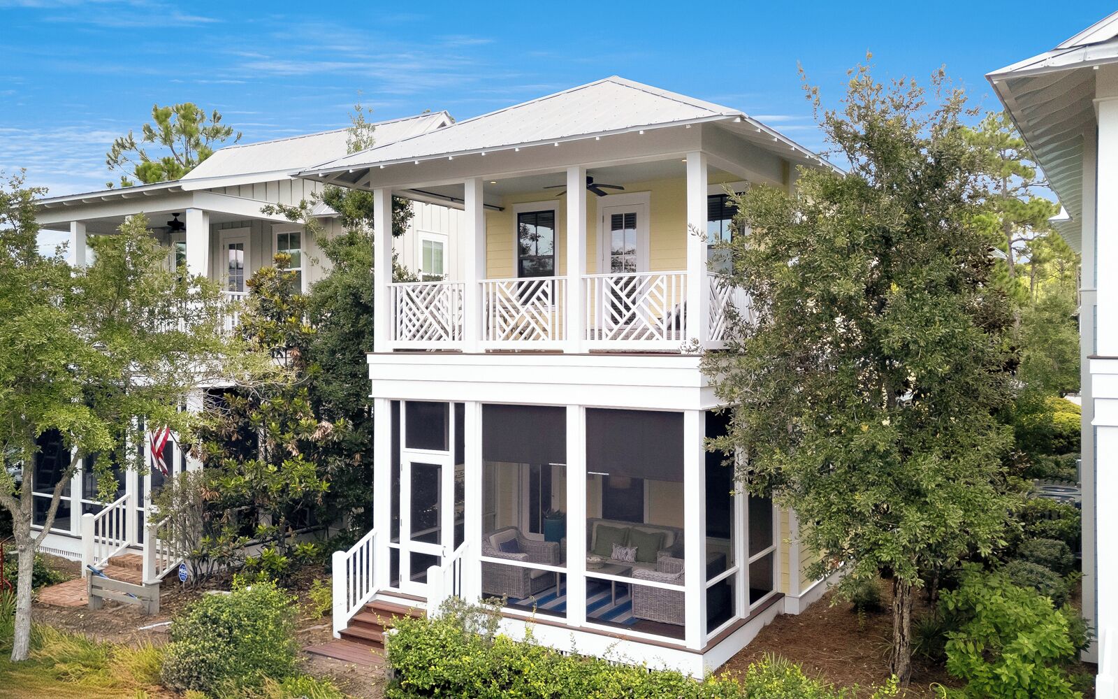 A two-story building with a balcony, large windows, and a covered porch.