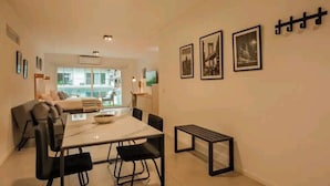 Una sala de estar moderna con comedor, que incluye un sofá, una mesa de comedor con sillas y un banco.