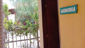 Une entrée d’immeuble avec une enseigne indiquant « HARMONIA » et une porte en bois.