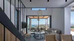 Un interior moderno con una zona de estar, una mesa de comedor y vistas al exterior.