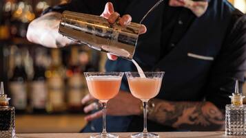 Un barman verse une boisson dans deux verres.