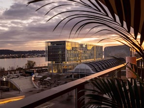 A modern building with a glass facade, located near a waterfront with a view of the river. - Hotel 56 Bordeaux - Handwritten Collection (Bordeaux)
