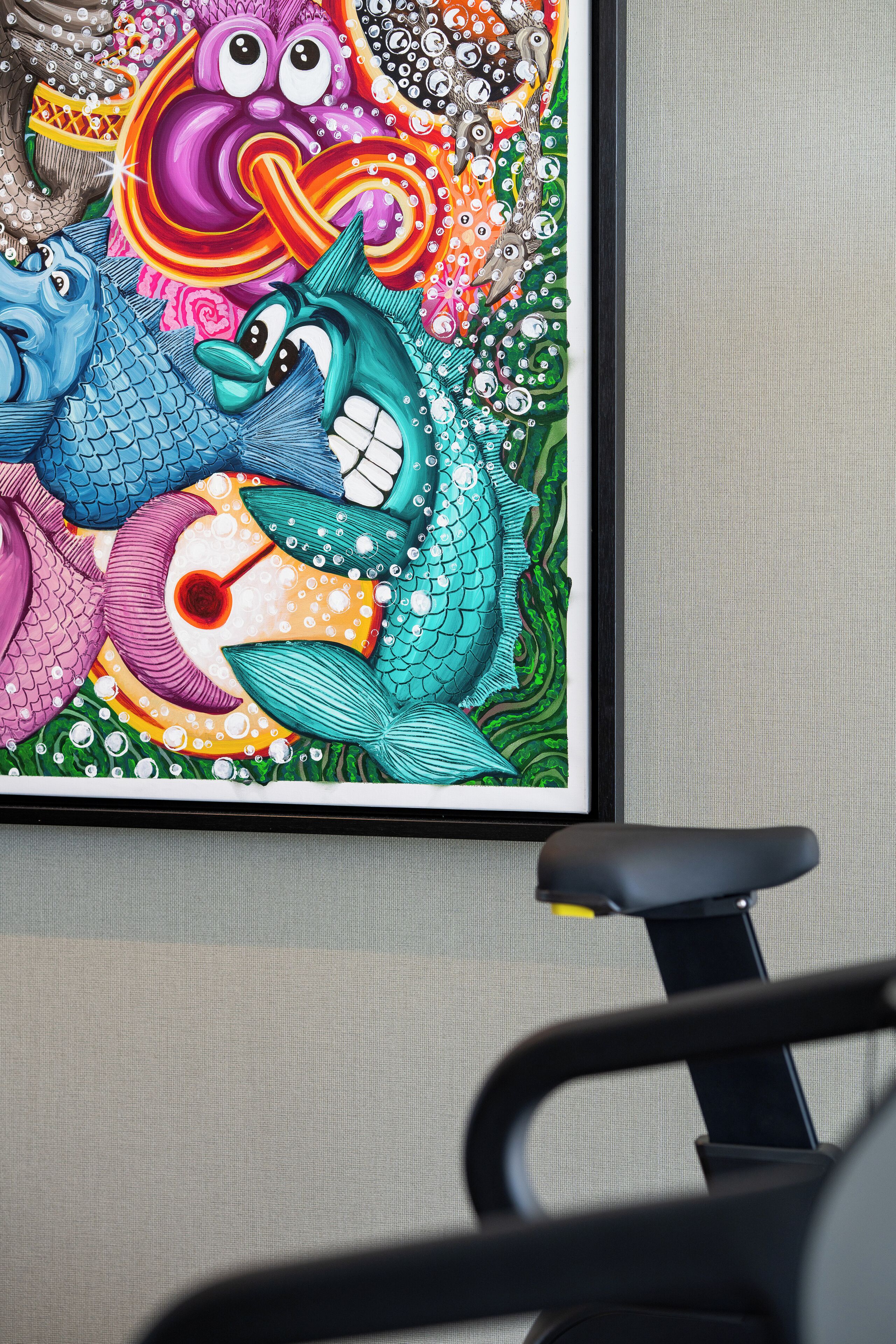A colorful painting of fish on a wall.