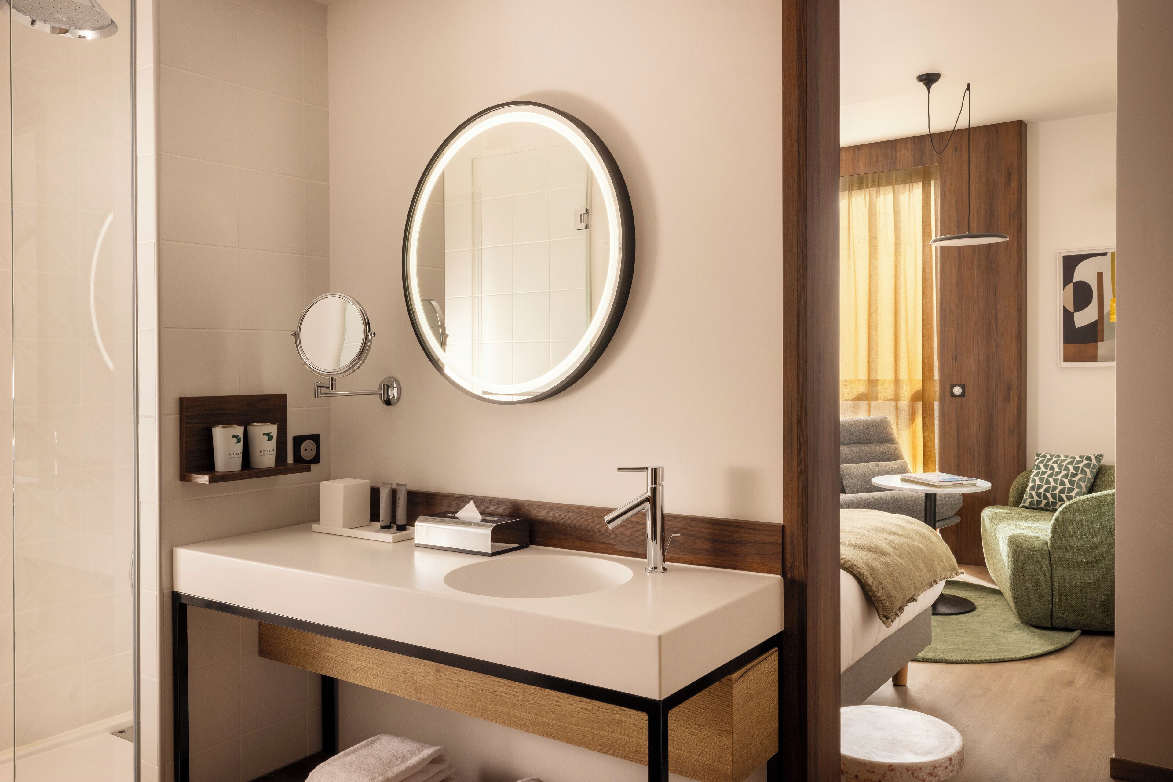 Un baño moderno con un espejo grande, un lavamanos y una ducha.