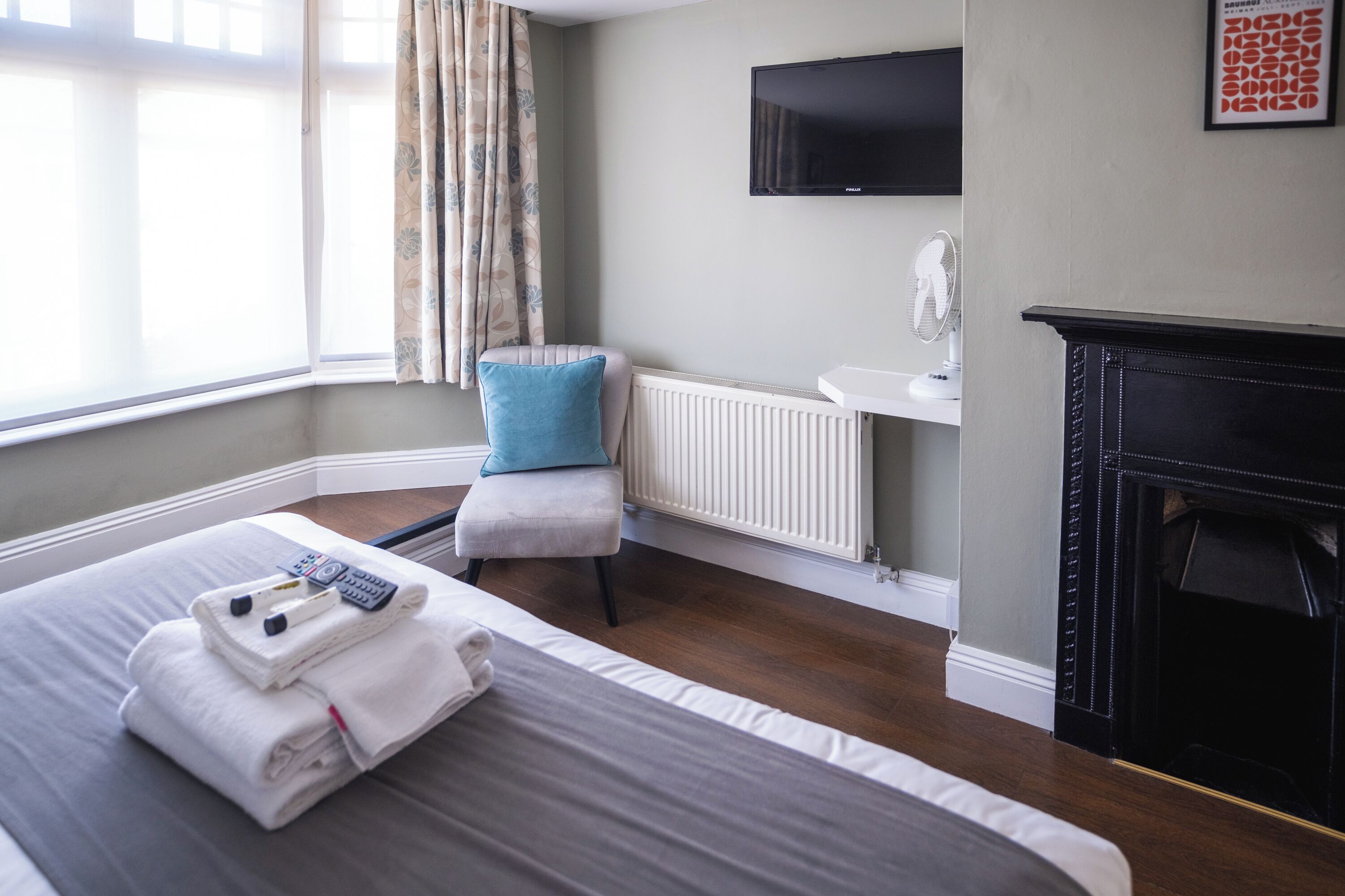 Une chambre d’hôtel équipée d’un lit, d’une chaise, d’une télévision, d’un radiateur et d’une cheminée.