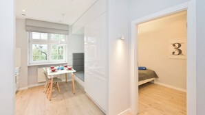 A compact room with a dining table, a bed, and a window. - Apartament Lili by Q4Apartments  (Gdansk)