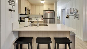 A modern kitchen with a central island, stainless steel appliances, and a minimalist design.