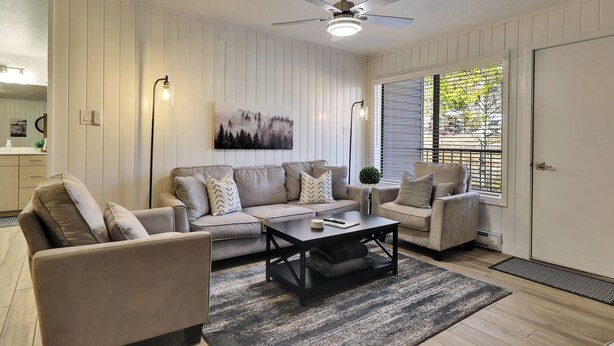A living room with a sofa set, a coffee table, and a ceiling fan.