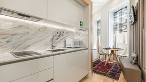 A modern kitchen with marble countertops, a built-in microwave, and a sink. - Welcoming Central Studio by PortoDreamStays (Porto)