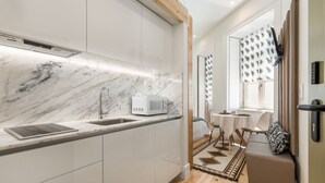 Une cuisine moderne dotée d’un plan de travail en marbre, d’un four à micro-ondes et d’un évier.