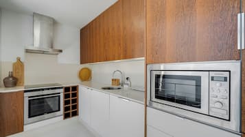 Een koelkast met diepvriezer, een microgolfoven, een oven, een kookplaat