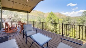 A covered deck with outdoor furniture, a ceiling fan, and a view of a mountainous landscape. - Games & Outdoor Seating: Cabin in Scenic Payson! (Payson)