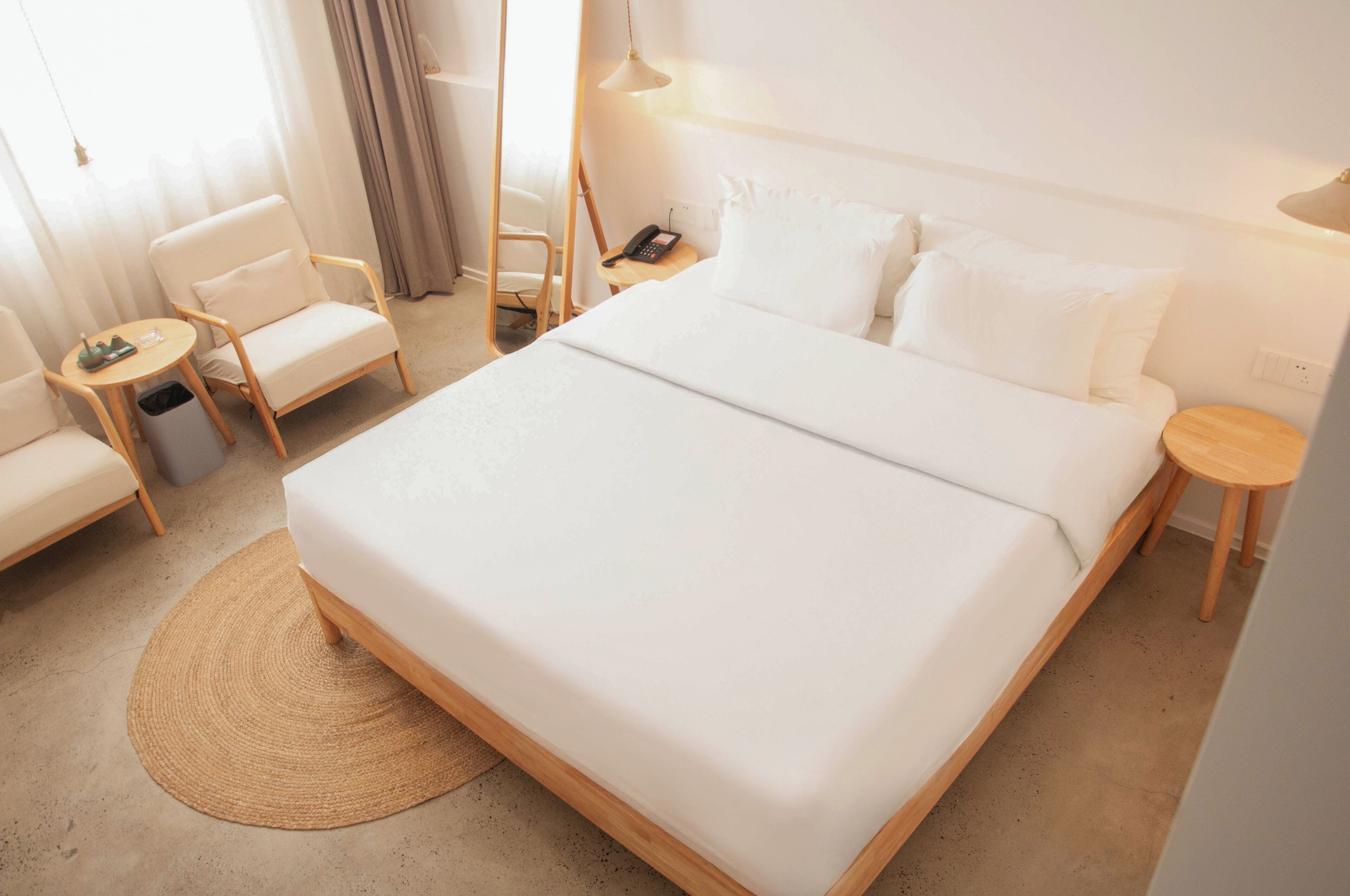 Une chambre d’hôtel avec un grand lit, une chaise, une petite table et une table de chevet.