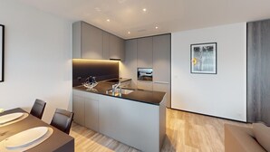 A modern kitchen with a central island, a dining area with a table and chairs, and a minimalist decor.
