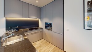 A modern kitchen with a built-in oven, a stainless steel sink, and a countertop.
