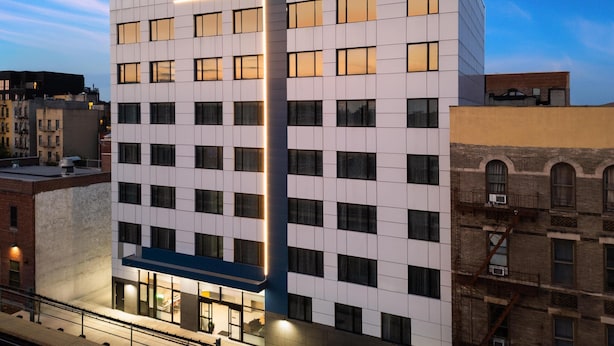 Un hôtel moderne, doté d’une façade à motifs géométriques et d’une enseigne « GLO » bien visible.