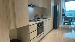 Une cuisine moderne avec des meubles en bois, un évier en acier inoxydable et un four encastré.