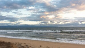 Ein Strand mit Wellen und bewölktem Himmel.