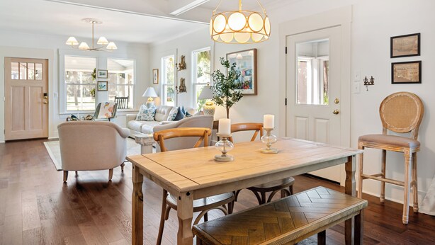 A dining area with a wooden table, chairs, and a chandelier. - Beautifully restored cottage downtown Historic Brunswick close to golf + beaches (Brunswick)
