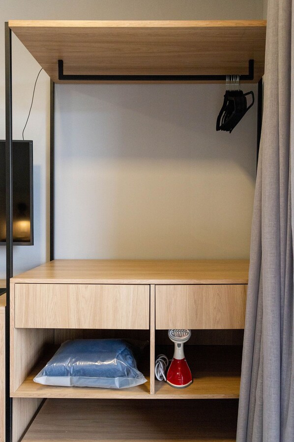 A wooden bunk bed with a desk and shelves, a red water bottle, and a black hairdryer. - Brooklyn Studios (São Paulo)