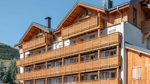 A multi-story wooden building with balconies, likely a hotel or resort.