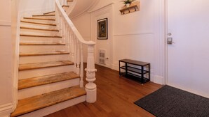 A staircase with wooden steps and white balusters, leading to a door marked with the number 2. - Remparts 2 Bed w Private terrace & sauna (Québec)