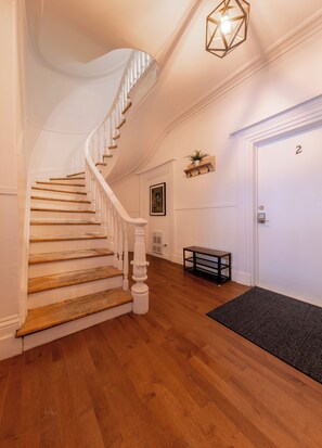 Staircase leads to an upper floor with a numbered entryway and a cozy seating area.
