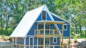 A multi-level wooden cabin with a metal roof, surrounded by trees. - SMITH LAKE CABIN-Cave, Dock,  (Crane Hill)