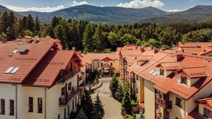 A hotel with red-tiled roofs, multiple balconies, and a central courtyard. - Instytut Zdrowia Sofra Fit & SPA Karpacz (Karpacz)