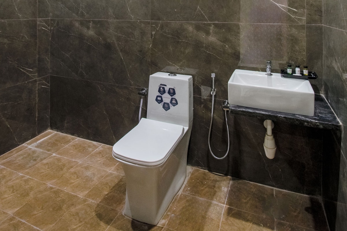 Une salle de bain avec des toilettes, un lavabo et une douche.