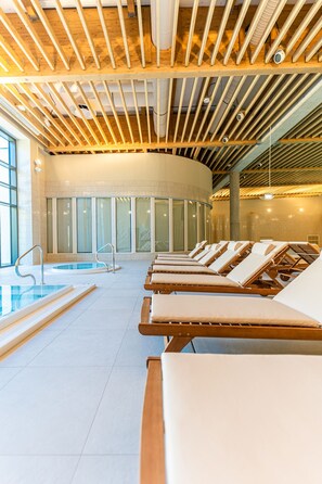 A spa area with a pool, sun loungers, and a wooden ceiling. - Instytut Zdrowia Sofra Fit & SPA Mielno (Mielno)