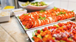 A buffet table with various food items including sliced tomatoes, a salad, and other dishes. - Instytut Zdrowia Sofra Fit & SPA Mielno (Mielno)