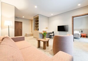 A modern hotel room with a sofa, armchair, TV, desk, and a walk-in closet. - Instytut Zdrowia Sofra Fit & SPA Mielno (Mielno)