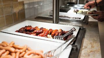 A buffet with various meats and sausages.