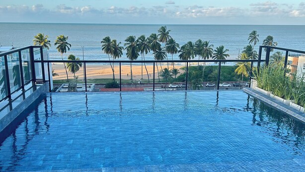 An infinity pool with a clear view of the beach and ocean. - Melhores Flats - Espaçoso a 100m do mar (João Pessoa)