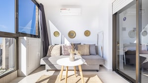 A modern living room with a sofa, a small round table, and decorative plates on the wall.
