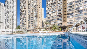 A swimming pool with a clear blue water surface, surrounded by high-rise residential buildings.