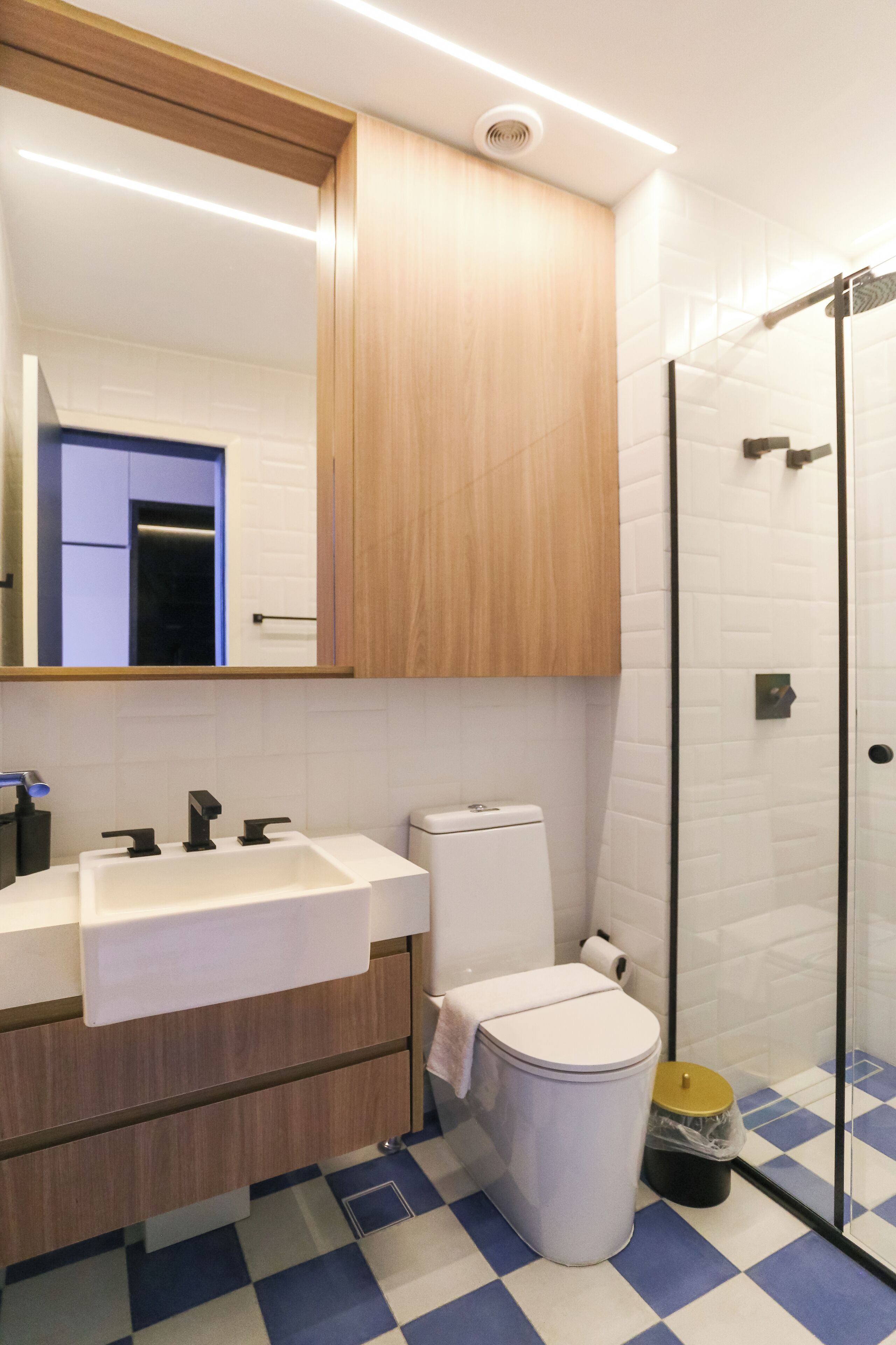 Ein modernes Badezimmer mit einem weißen Waschbecken, einer Toilette und einer Duschkabine aus Glas.