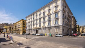 Un edificio de varios pisos con un estilo arquitectónico clásico, que presenta una entrada central y varios balcones.