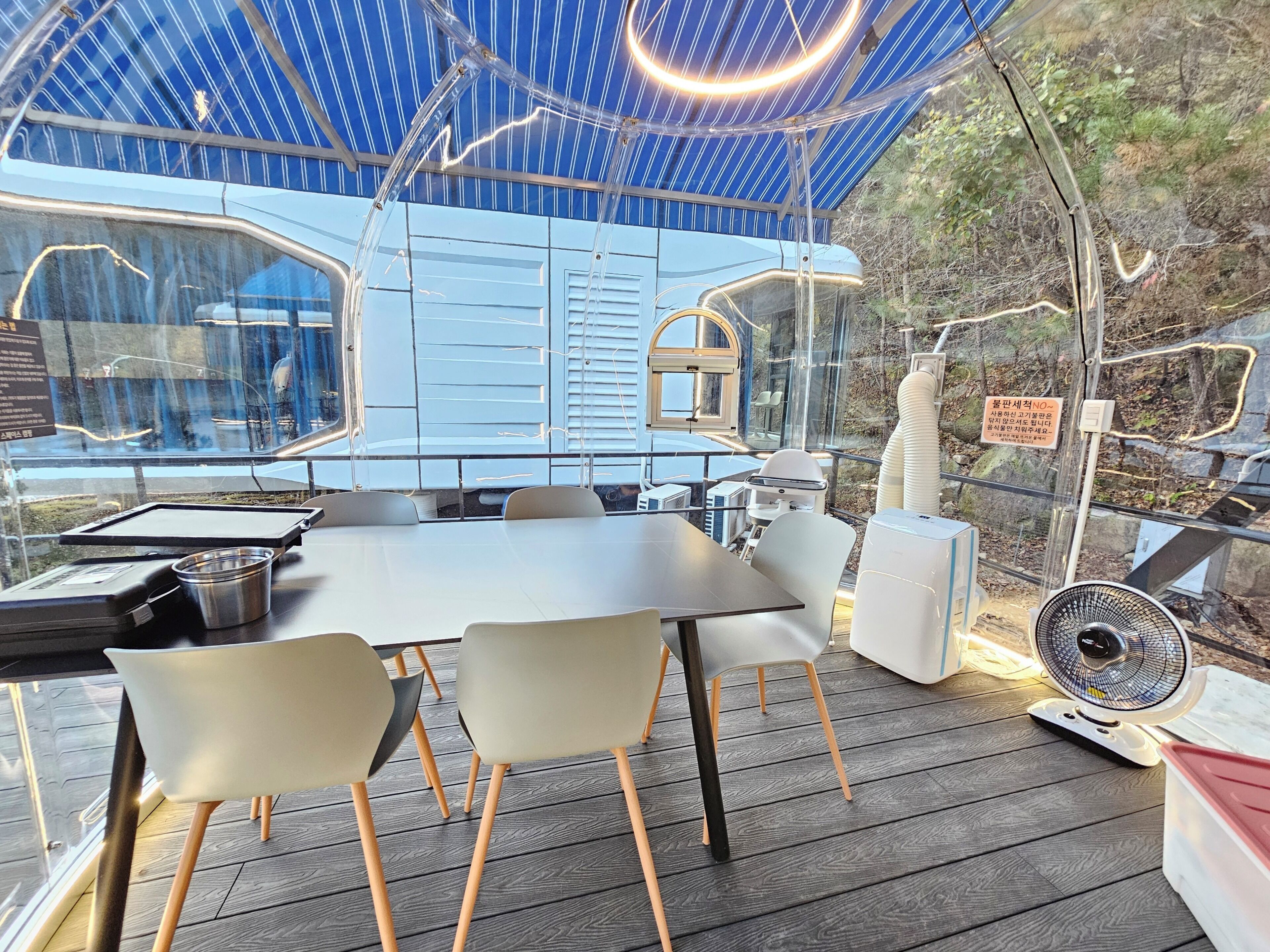 A modern dining area with a table, chairs, and a fan.