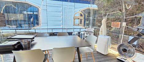 A modern dining area with a table, chairs, and a fan.